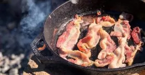 Bacon i stekepanne på bål.